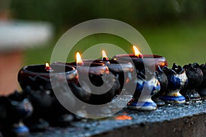 Burning candles and oil lamps in a buddhist temple in Thailand