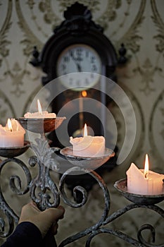 Burning candles in old candlestick in human hand