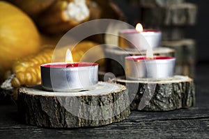 Burning Candles With Pumpkins, Corncob, autumn leaves in the background. Thanksgiving Day, Decoration on a wooden table