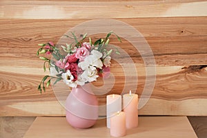 Burning candles and vase with flowers on table