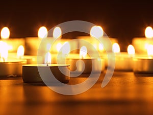 Burning candles with a yellow flame on a black table with a blurred background. Christmas candles. Lighted candles at night in the