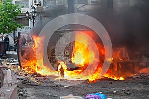 Burning car in the center of city during unrest photo