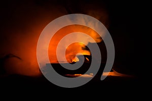 Burning car on a dark background. Car catching fire, after act of vandalism or road indicent