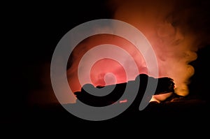 Burning car on a dark background. Car catching fire, after act of vandalism or road indicent