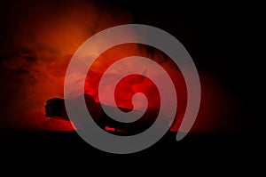 Burning car on a dark background. Car catching fire, after act of vandalism or road indicent