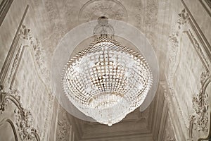 Burning chandelier on ceiling in narrow photo