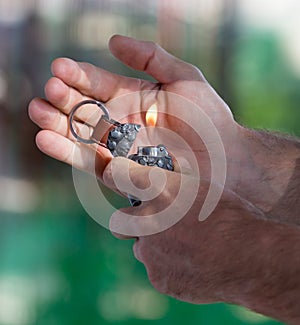 Burning cigarette lighter in his hand
