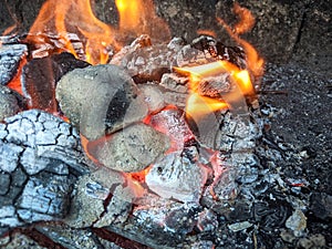 Burning coals, wood and ashes in the hot oven