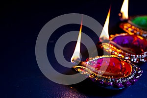 Burning decorated ceramic oil lamp diya, on Happy Diwali, Shubh Diwali with beautiful dark blue background, copy space