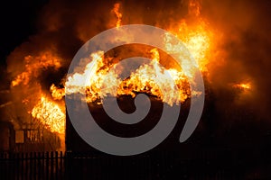 Burning fire flame on wooden house roof