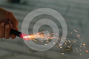 Burning Firecracker with Sparks. Guy Holding a Petard in a Hand