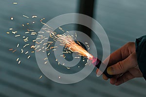 Burning Firecracker with Sparks. Guy Holding a Petard in a Hand