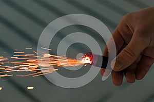 Burning Firecracker with Sparks. Guy Holding a Petard in a Hand
