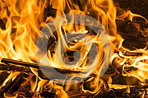 Burning firewood in the fireplace close up, BBQ fire, charcoal background.