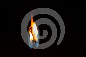 Burning flame on a black matchstick