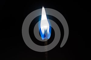 Burning flame on a black matchstick