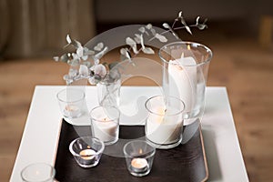 Burning fragrance candles on table at cozy home