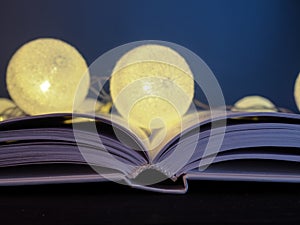 A burning garland of balloons lies on an open book