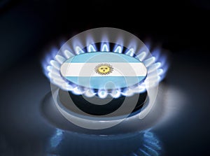 Burning gas burner of a home stove in the middle of which is the flag of the country of Argentina. Gas import and export delivery