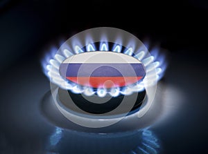 Burning gas burner of a home stove in the middle of which is the flag of the country of Russia. Gas import and export delivery
