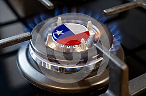 A burning gas burner of a home stove, in the middle of which a flag is depicted - Chile