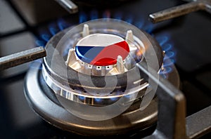 A burning gas burner of a home stove, in the middle of which a flag is depicted - Czech