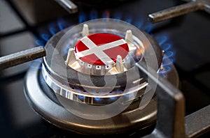 A burning gas burner of a home stove, in the middle of which a flag is depicted - Denmark