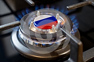 A burning gas burner of a home stove, in the middle of which a flag is depicted - Russia