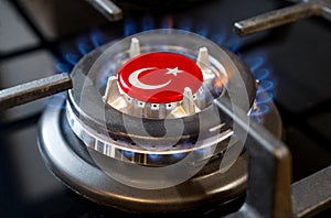 A burning gas burner of a home stove, in the middle of which a flag is depicted - Turkey