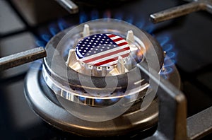 A burning gas burner of a home stove, in the middle of which a flag is depicted - USA