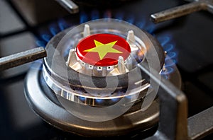 A burning gas burner of a home stove, in the middle of which a flag is depicted - Vietnam