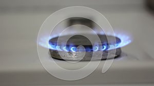 A burning gas burner. The kitchen gas burner burns in blue. A gas burner burns in the kitchen.