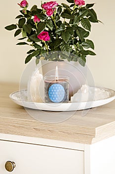 Burning glass candle with homemade sign showing Flower of Life symbol in home interior with semi precious stone geodes. photo