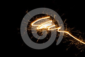 Burning gold sparkler line as swirl, spiral or funnel on black background.