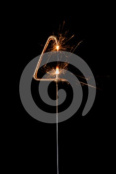 Burning golden sparkler in shape of number four, digit 4, isolated on black