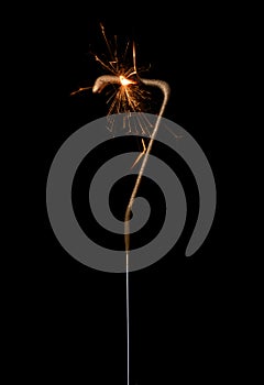 Burning golden sparkler in shape of number seven, digit 7, isolated on black