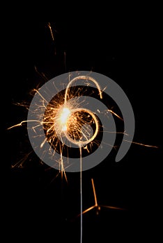 Burning golden sparkler in shape of number six, digit 6, isolated on black