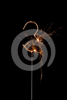 Burning golden sparkler in shape of number three, digit 3, isolated on black