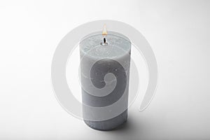 Burning grey wax candle isolated