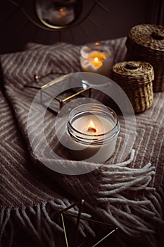 Burning hand-made candle with wooden wick in glass jar