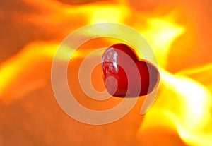 Burning heart with flames against fire background