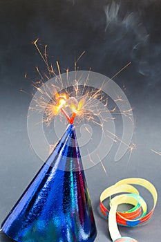 Burning heart on party hats, black background, birthday card