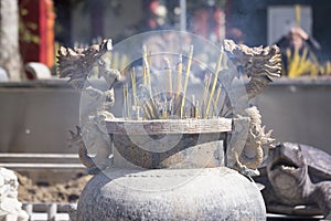 Burning incense stick in dragon decorated censer