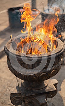 Burning incense sticks in old stone pot at Sacred Sri Maha Bhodi Gardens