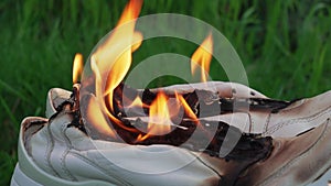 Burning leather sports shoes. Sneakers or gym shoes on fire stand on the Stump.