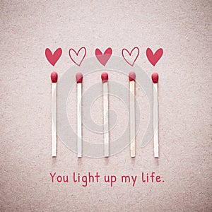 Burning love match with heart shape fire light with wording You light up my life valentine card