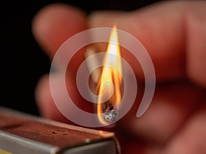 Burning match on a black background. Flame from a lit match.