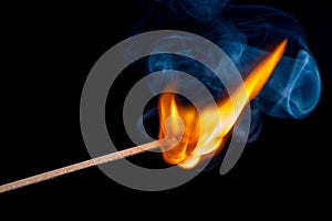 Burning match on black background