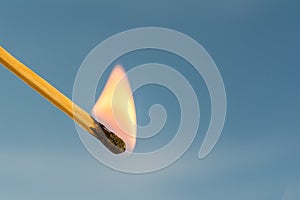 Burning match on a blue background