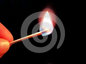 Burning match in hand on neutral background